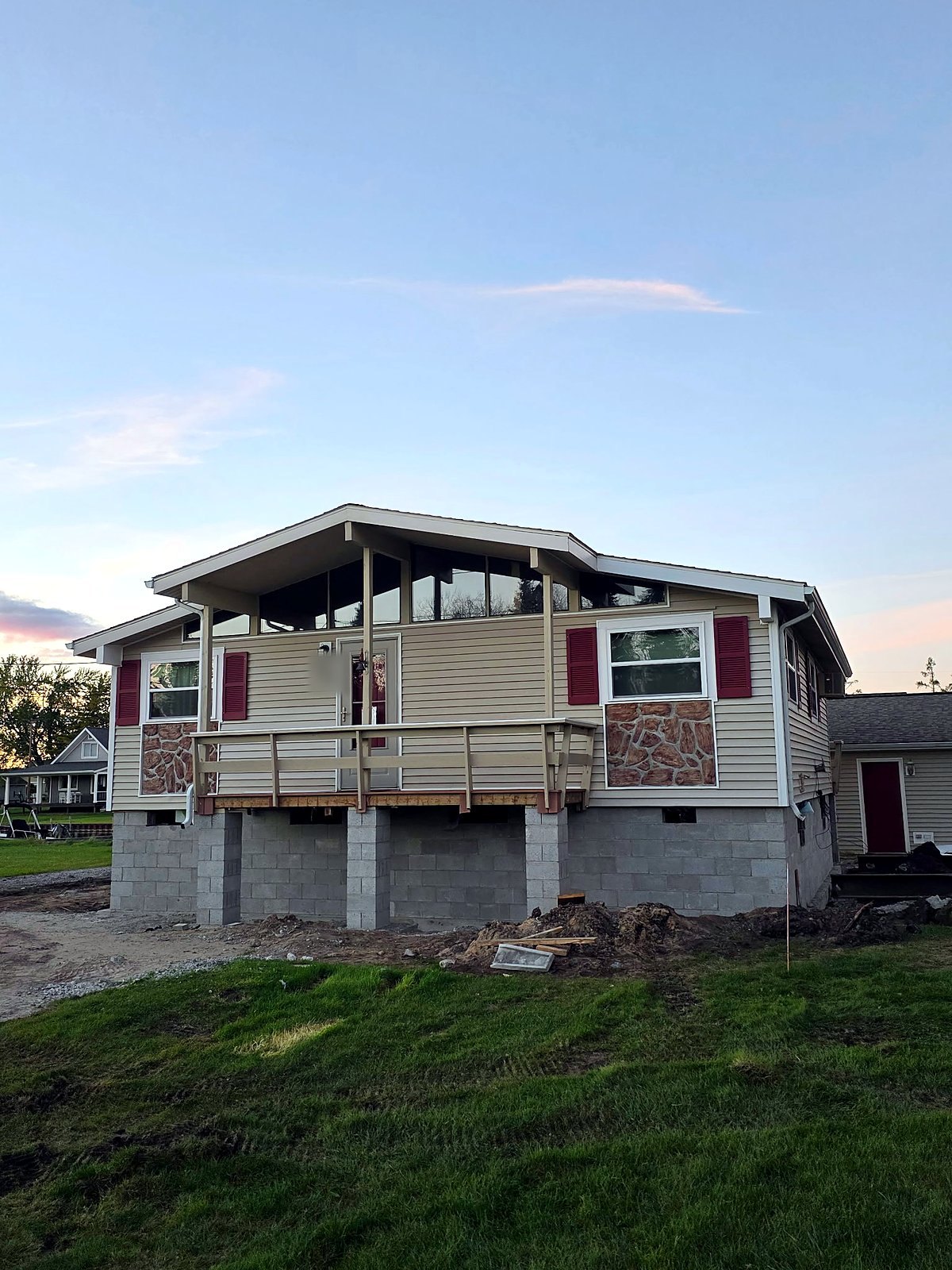 A house with a deck set on a new concrete block foundation at dusk